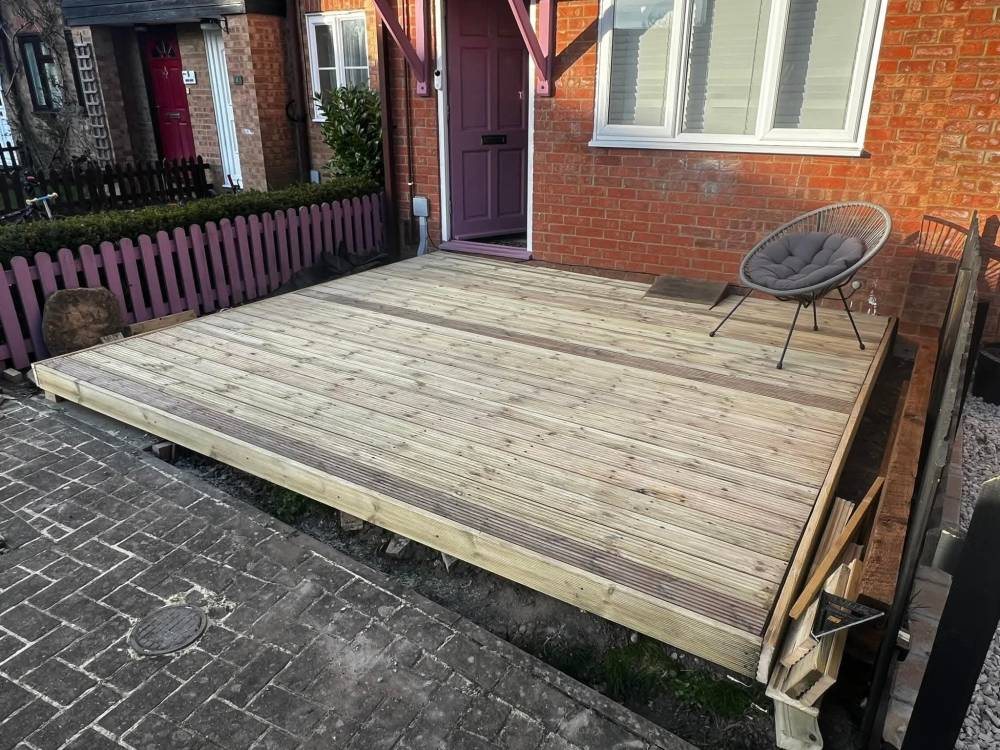 New timber decking laid outside a brick house